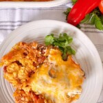 Taco Casserole on a serving plate with red bell pepper in the background.