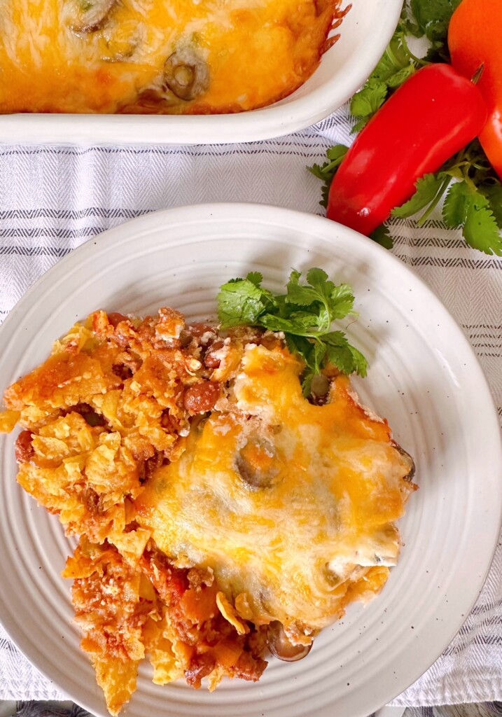 Taco Casserole on a serving plate with red bell pepper in the background.