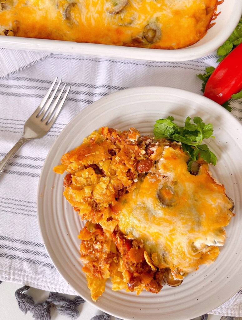 Taco casserole on a white dinner plate with a fork.