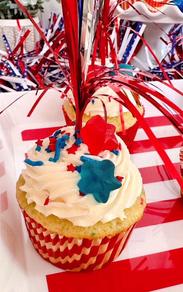 Single cupcake with frosting, sprinkles, and a cake poke decoration.