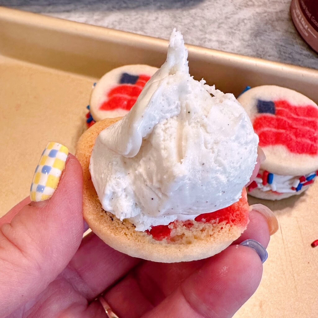 Placing a scoop of ice cream on a cookie.