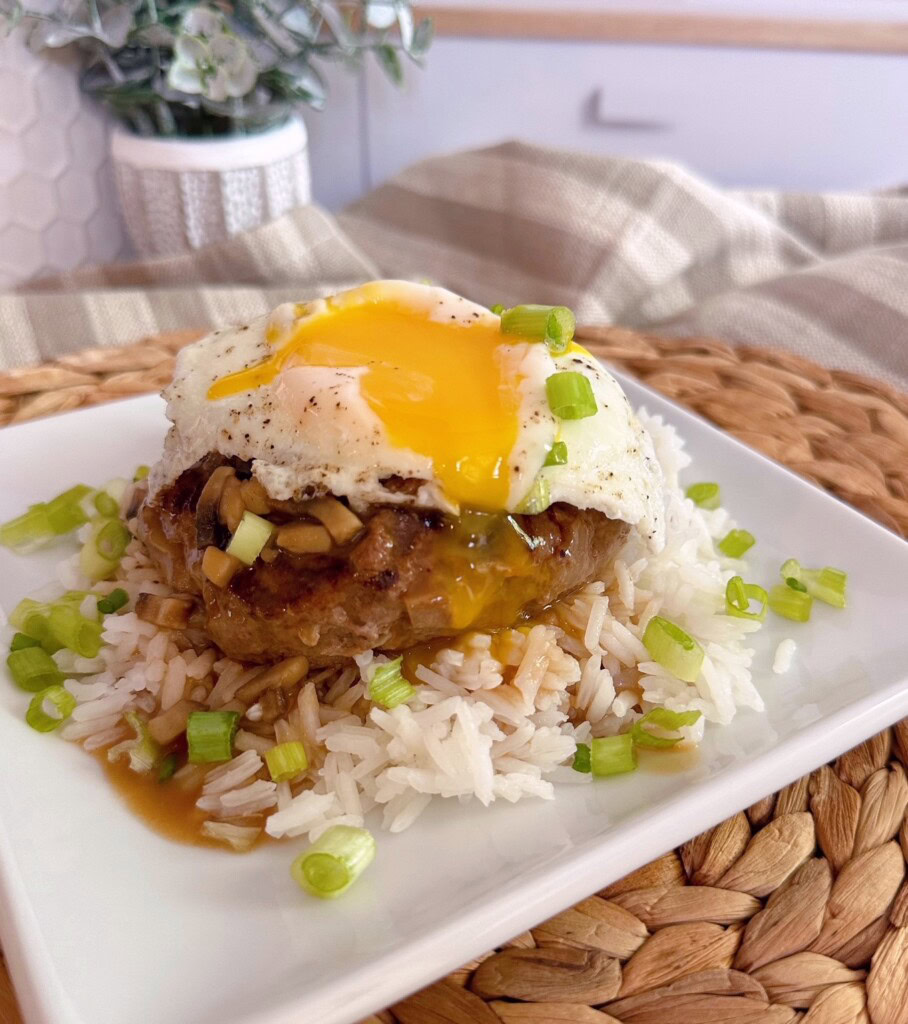Broken yolk over beef patty and rice.