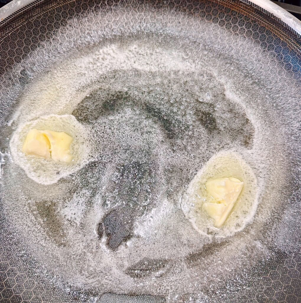 Melting butter in a large skillet.