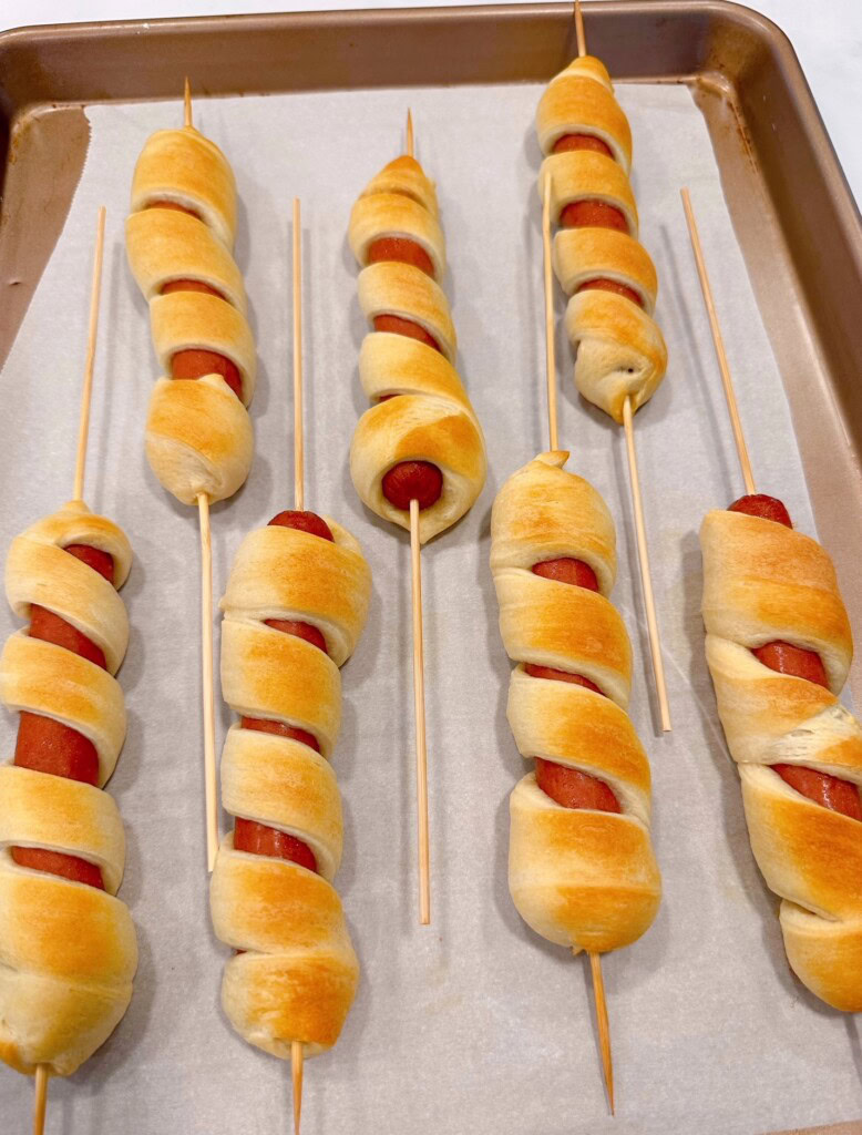 Cooked Stars and Stripes hot dogs on a baking sheet.
