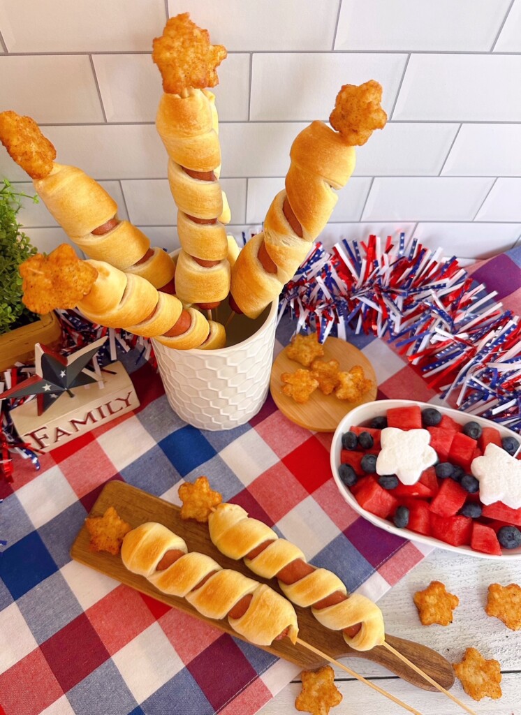 Stars and Stripes Hot Dog Skewers with tater tots on a red, white, and blue table cloth.