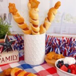 Stars and stripes hot dogs in a jar with a patriotic background.