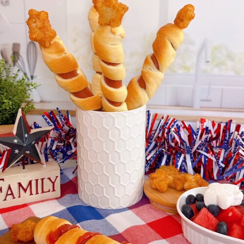 Stars and stripes hot dogs in a jar with a patriotic background.