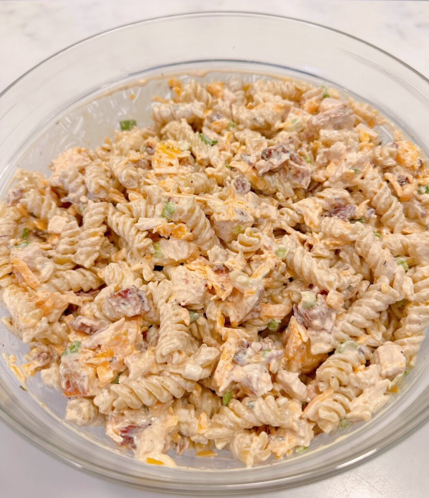 Chicken Bacon Ranch Pasta Salad mixed together in a large bowl ready to refrigerate.
