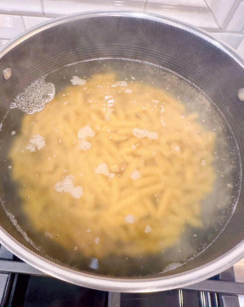 Pasta in boiling water on the stove top.