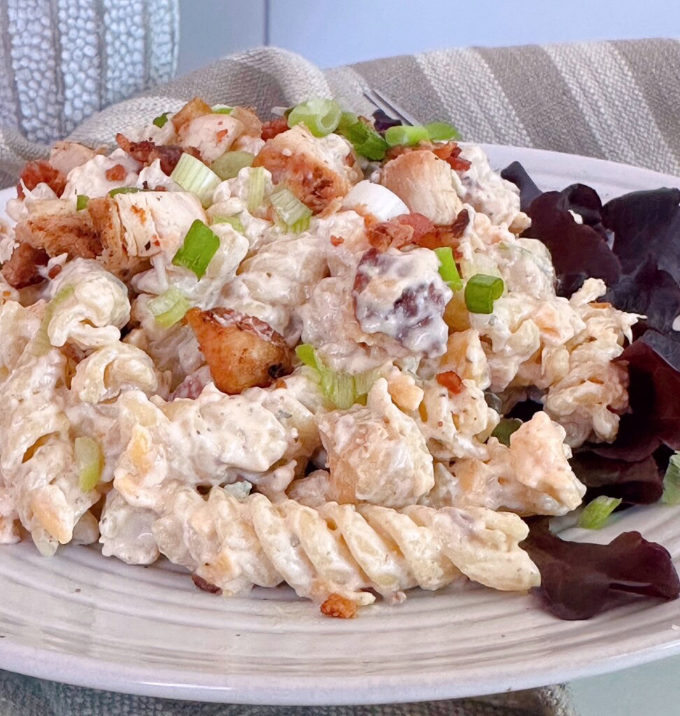 Pasta salad served on a bed of red leaf lettuce.
