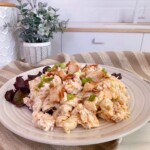 Serving of Chicken Bacon Ranch Pasta Salad on a rustic plate with red leaf lettuce.