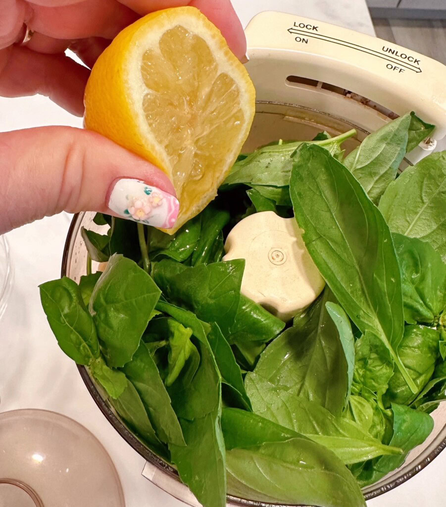 Adding lemon juice to pesto sauce.