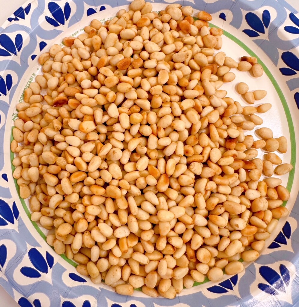 Toasted pine nuts on a paper plate.