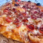 Baked pizza with meat toppings up close.