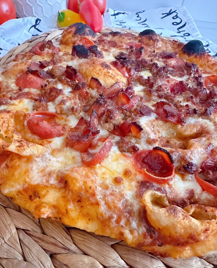Baked pizza with meat toppings up close.