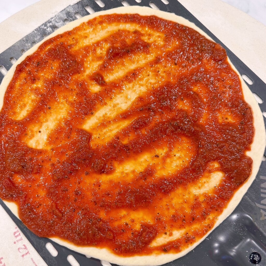 Pizza crust with sauce.
