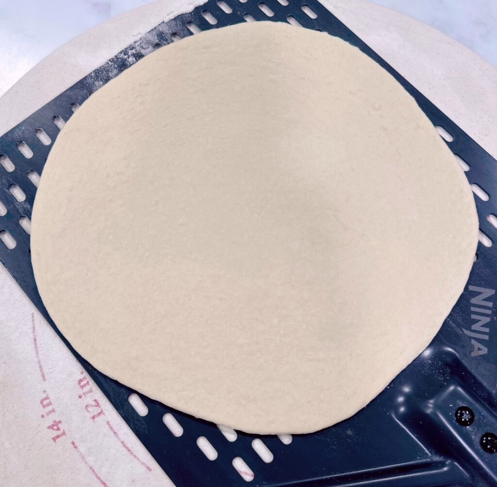 Dough transferred onto a pizza paddle.