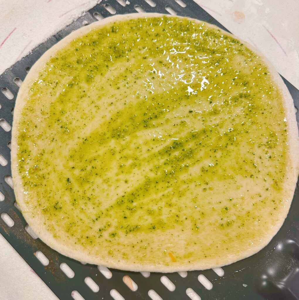 Pesto sauce brushed over crust.