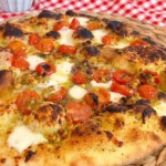 Up close photo of tomato basil pizza.