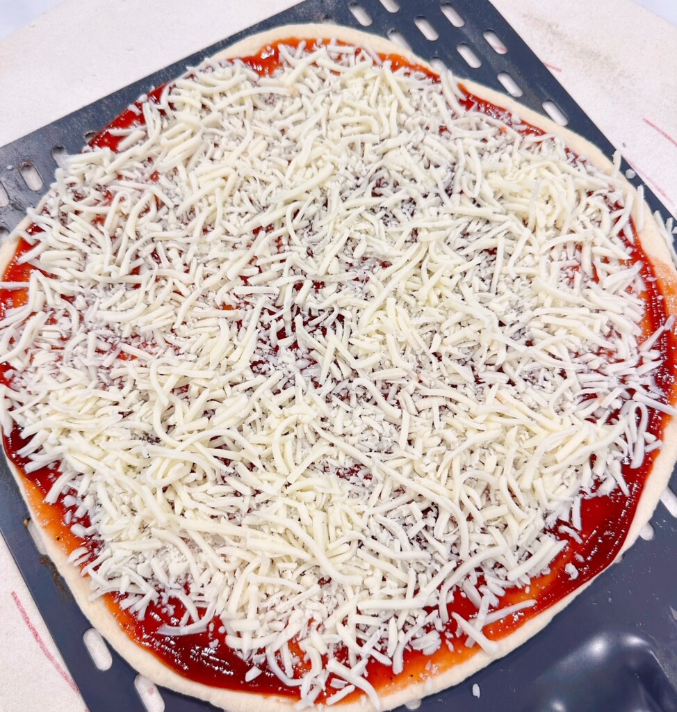 Cheese sprinkled over the top of pizza.
