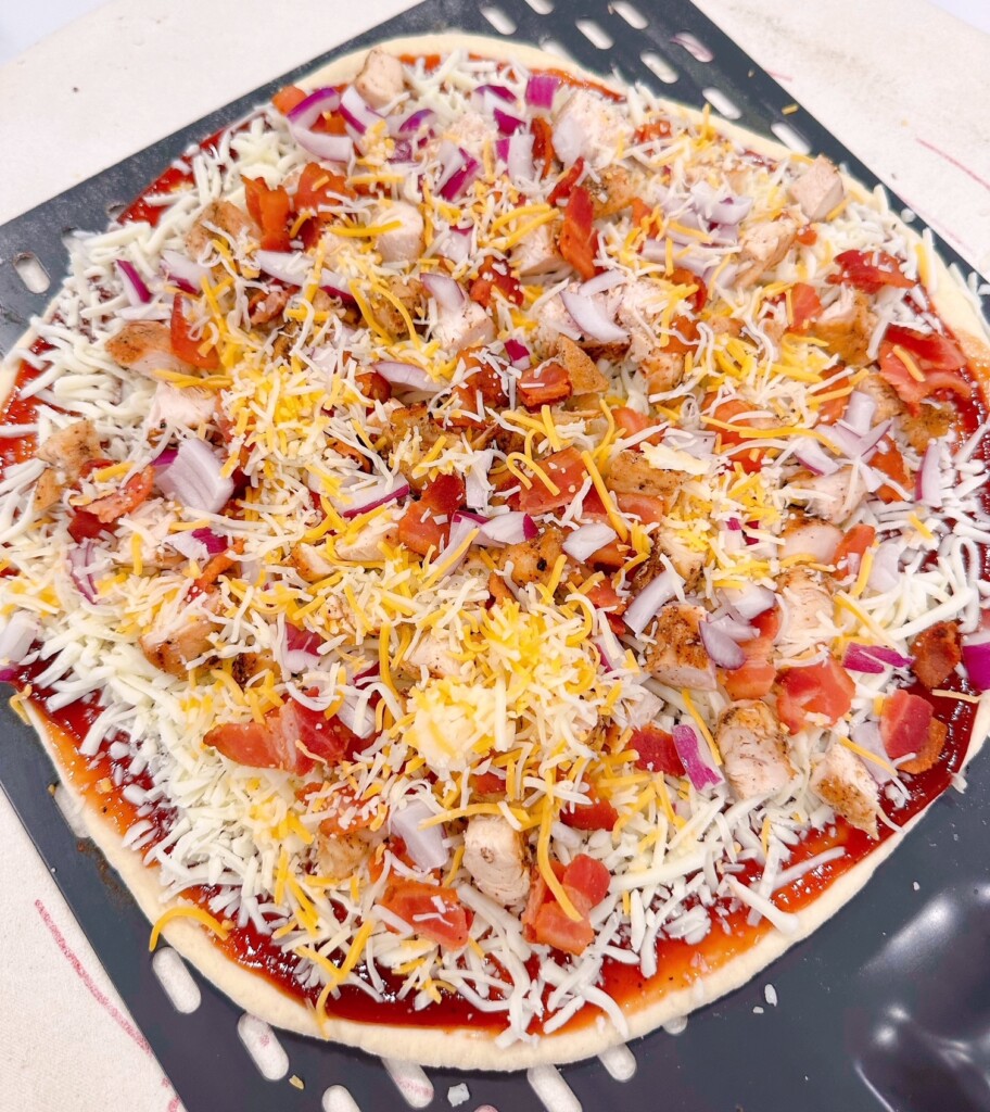Toppings sprinkled with cheddar cheese before baking.