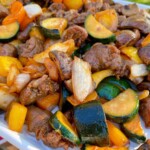 Grilled teriyaki steak and veggies upclose on a serving tray.