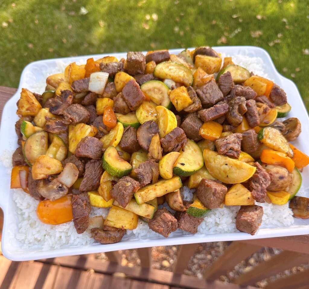 Summer Teriyaki Steak and Vegetables on a deck railing on a serving tray.