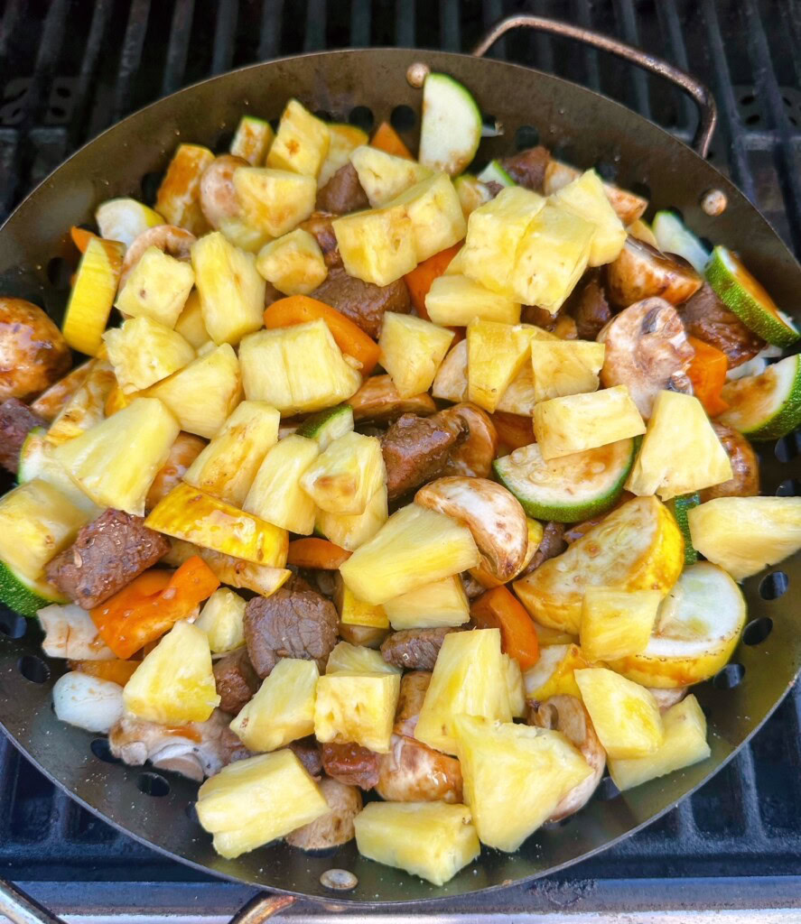 Add pineapple to the stir-fry veggies and steak.