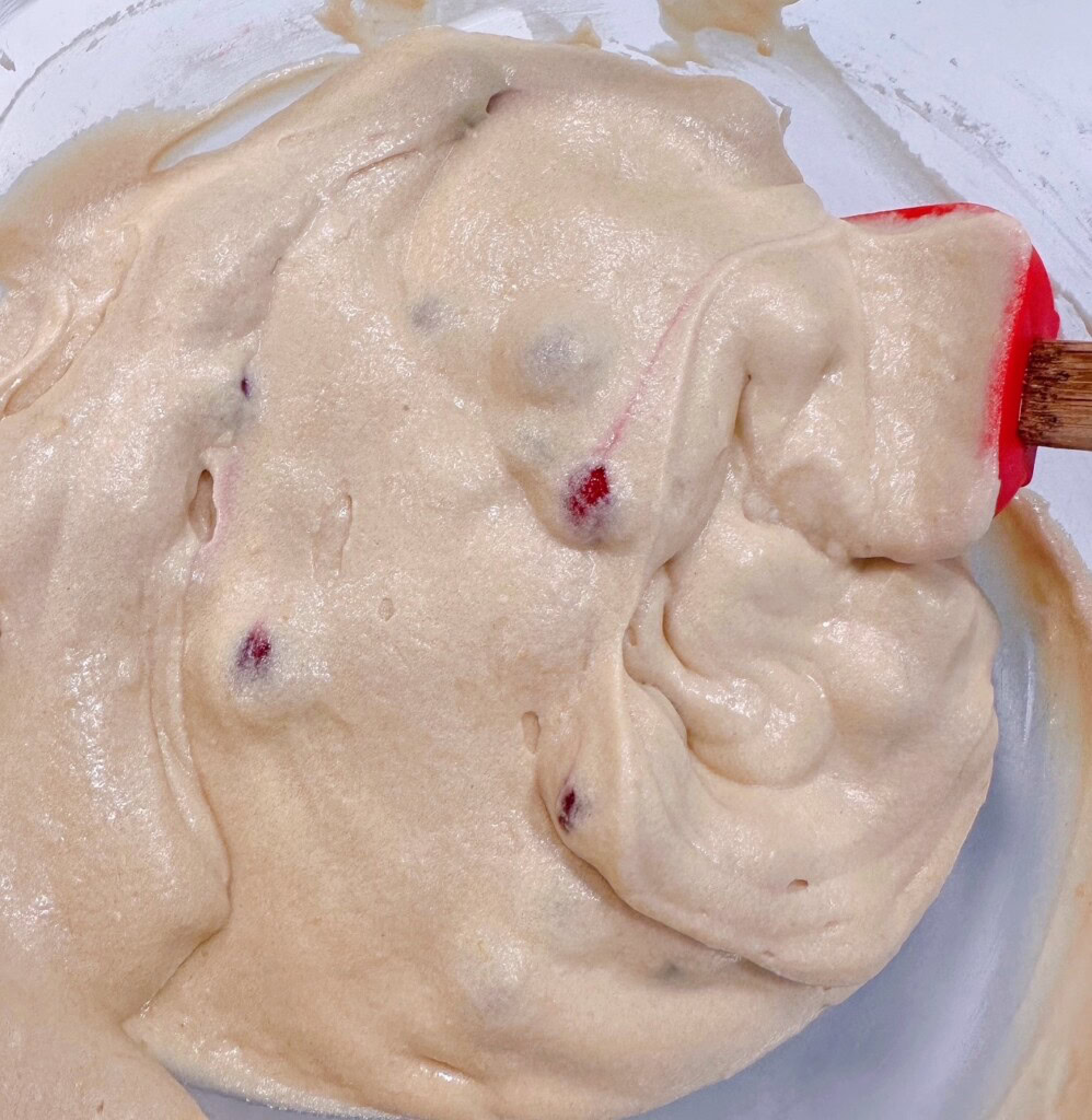 Stirring the cranberries into the cake batter.
