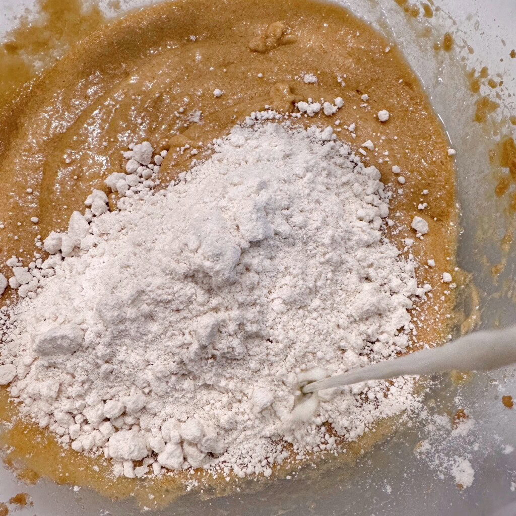Adding bisquick to cake batter mixture.