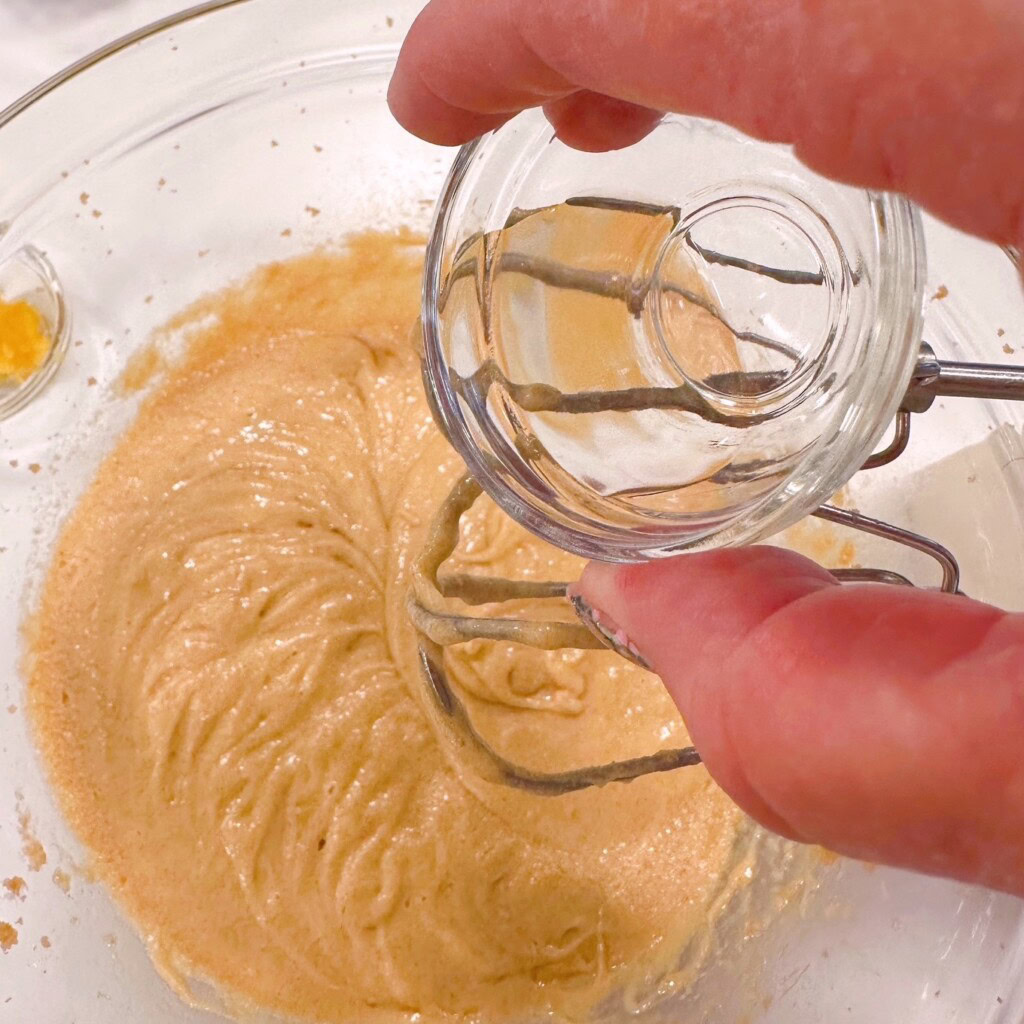 Adding Almond Extract to cake batter.