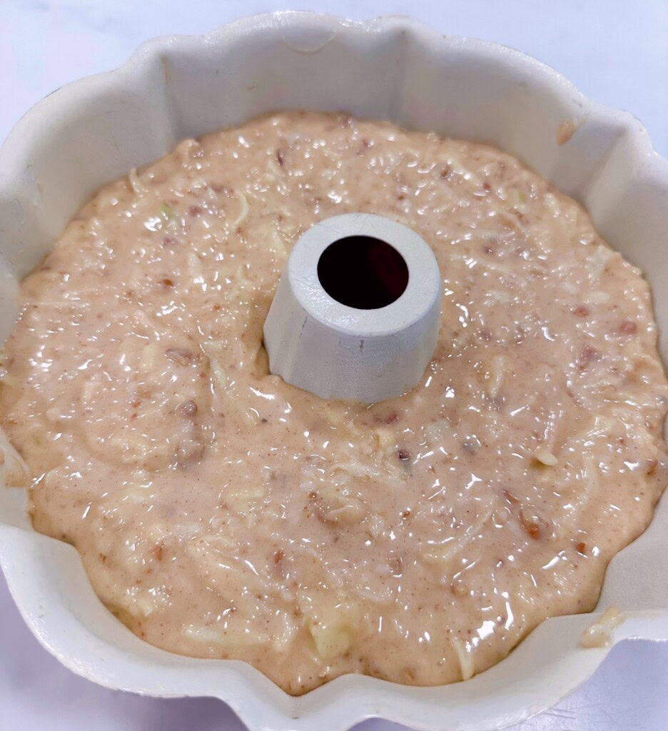 Apple cake batter in a bundt pan.