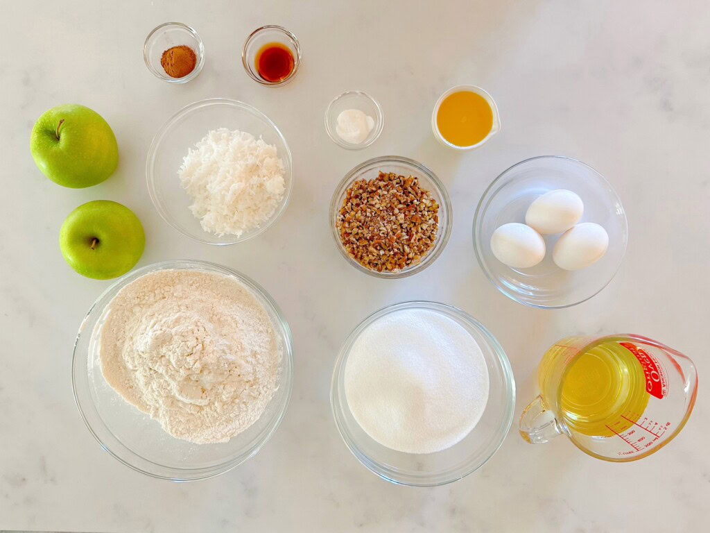 Apple cake ingredients on a white counter top.