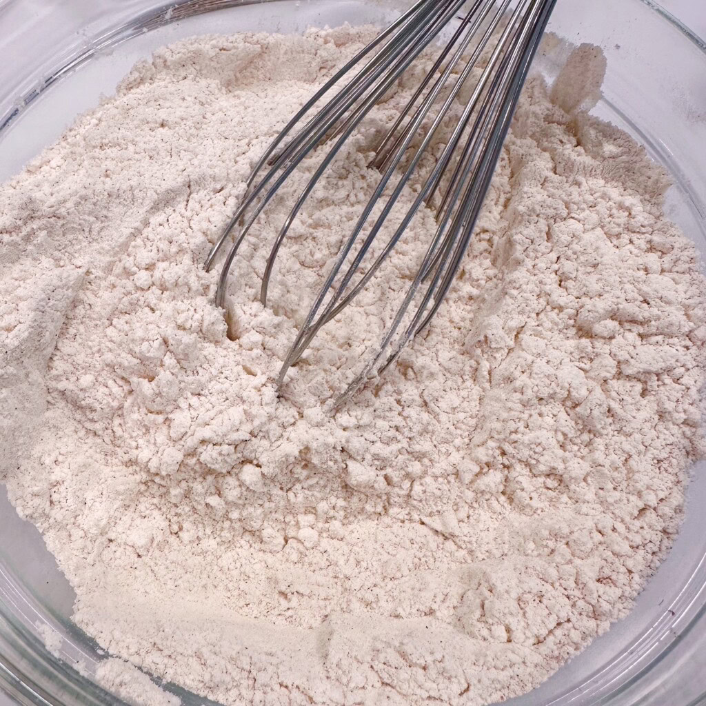 Whisking dry ingredients in a large bowl.
