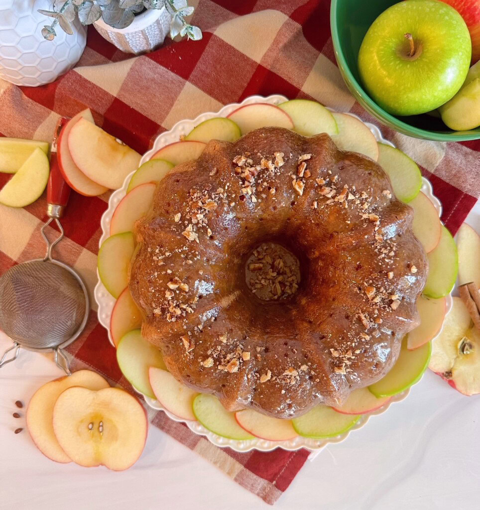 Apple Cake over head photo of cake on a cake plate with slices of apples all around it.