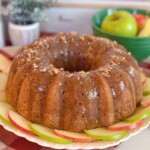 Apple Cake with Caramel Glaze on a cake plate surrounded by apple slices.