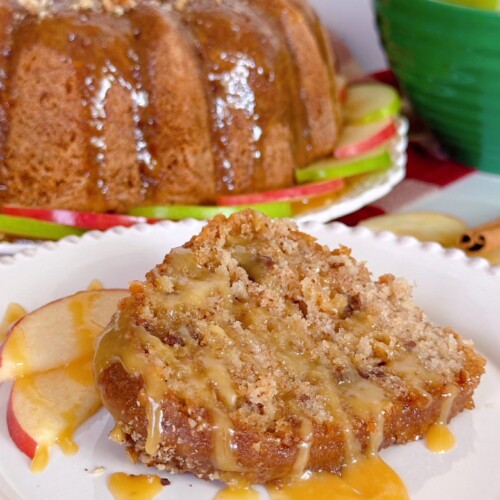 Apple Caramel Cake with a slice cut and drizzled with caramel sauce.