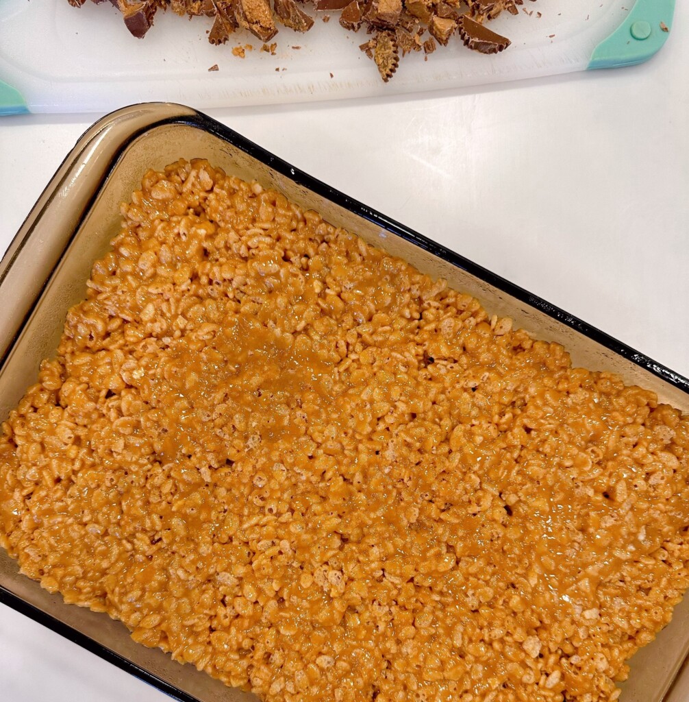 Rice krispie mixture patted down into a baking dish.