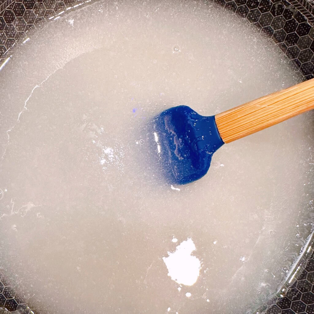 Combining Sugar and Corn Syrup in a large sauce pan on the stove top.