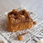 Best Ever Scotcheroos on a piece of newspaper with crumbs.