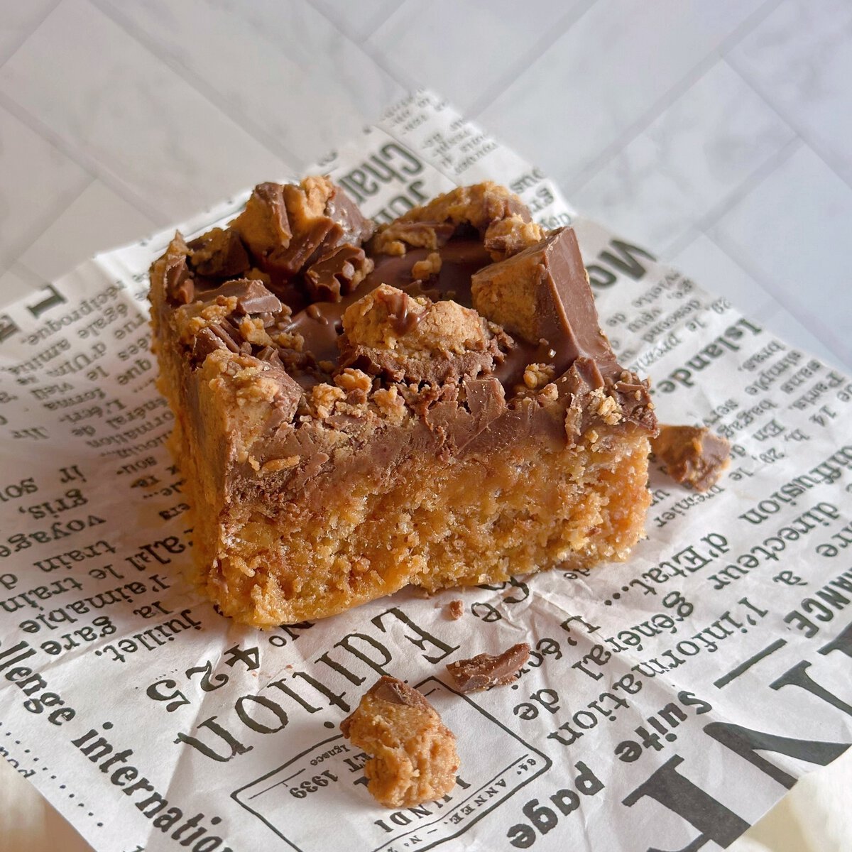 Best Ever Scotcheroos on a piece of newspaper with crumbs.